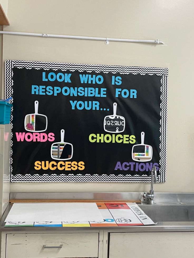 a bulletin board with words and pictures on it in an office cubicle area next to a sink