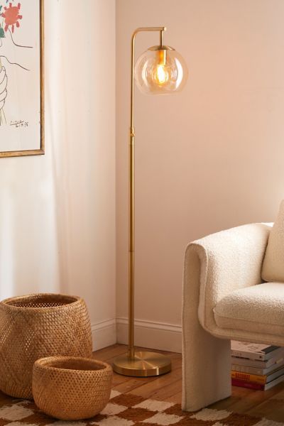 a living room scene with focus on the floor lamp and basket next to the couch