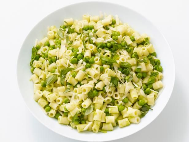 a white bowl filled with pasta and peas