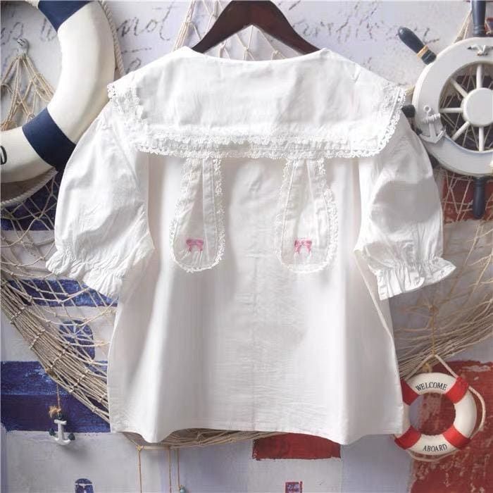 White Bunny Collar Kawaii Lolita Shirt with Pan Collar and Lace Bow Embroidery, available with short sleeves and long sleeves   ONE SIZE Bust: 104cm/41" Length: 56cm/22"     Material: COTTON, Polyester Kawaii Collared Shirt, Casual Short Sleeve Blouse With Lace Collar, Casual Blouse With Lace Collar And Short Sleeves, Cute White Blouse With Lace Collar, Casual Cotton Blouse With Peter Pan Collar, Casual Embroidered Blouse With Peter Pan Collar, Cute White Blouse With Doll Collar, Cute Fitted White Blouse, White Blouse With Doll Collar In Cute Style