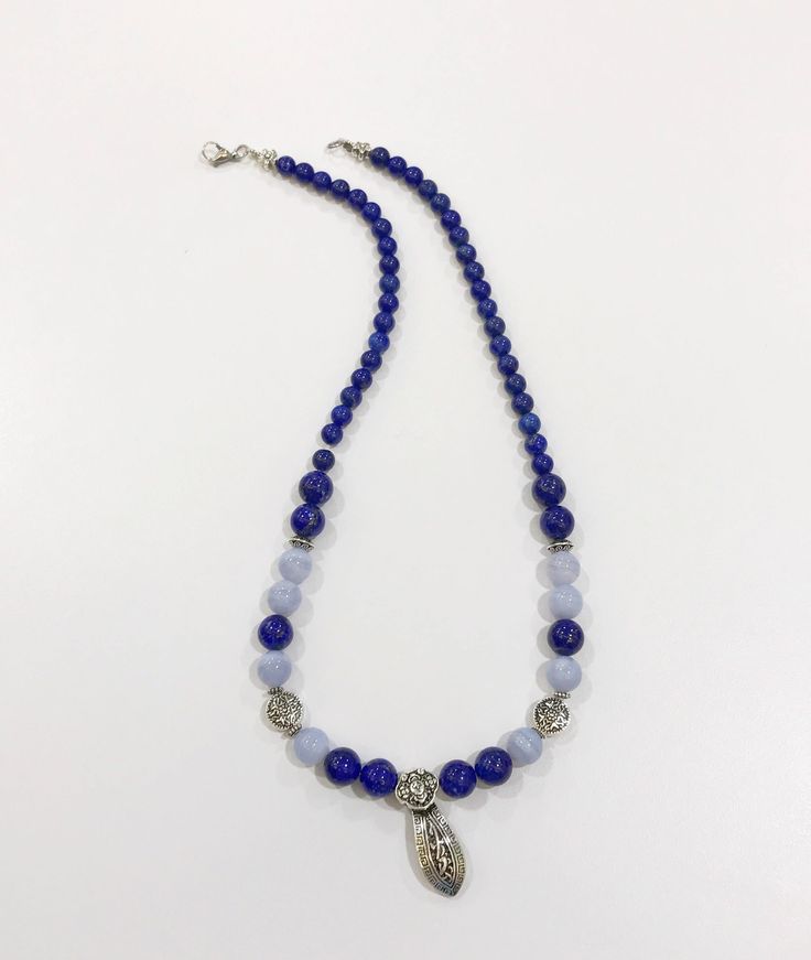 "Deep blue authentic lapis lazuli crystals contrast with blue lace agate brings out a stunning necklace with sterling silver spacers. The centrepiece is a RuYi scepter- representation of power and good fortune. A direct translation of RuYi 如意- is \"as u wish\". A traditional ruyi has a long S-shaped handles and a head fashioned like a cloud. Frequently appears in Asian art as a good luck motif. Lapis lazuli improves throat and lung health - in tune with personal spirit guardians to guide the wea Blue Spiritual Crystal Necklace With Polished Beads, Blue Lapis Lazuli Necklace For Meditation, Spiritual Blue Crystal Necklace With Polished Beads, Blue Polished Beads Spiritual Crystal Necklace, Blue Gemstone Symbolic Necklace, Blue Lapis Lazuli Amulet Jewelry, Blue Amulet Jewelry For Healing, Symbolic Blue Gemstone Necklaces, Symbolic Blue Gemstone Necklace