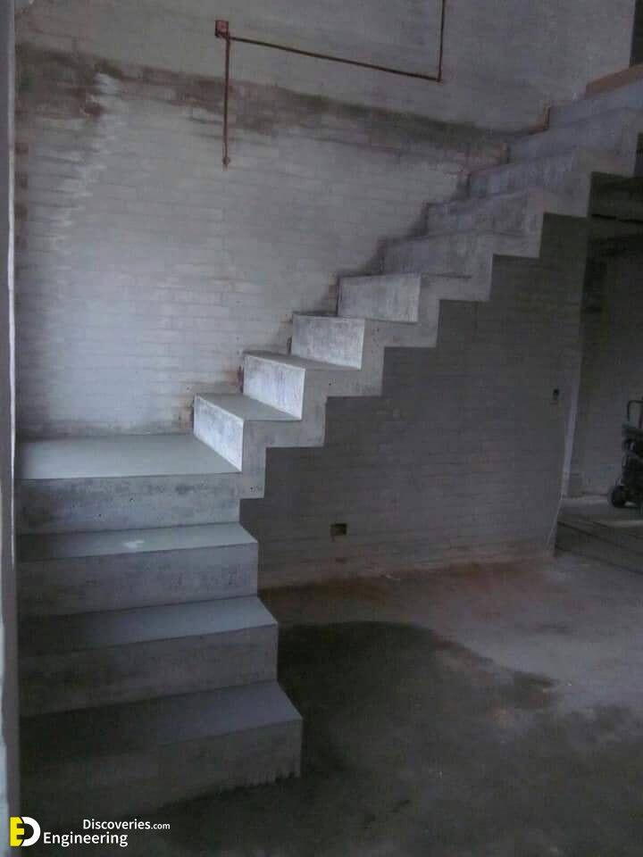 an empty room with white brick walls and concrete steps leading up to the second floor