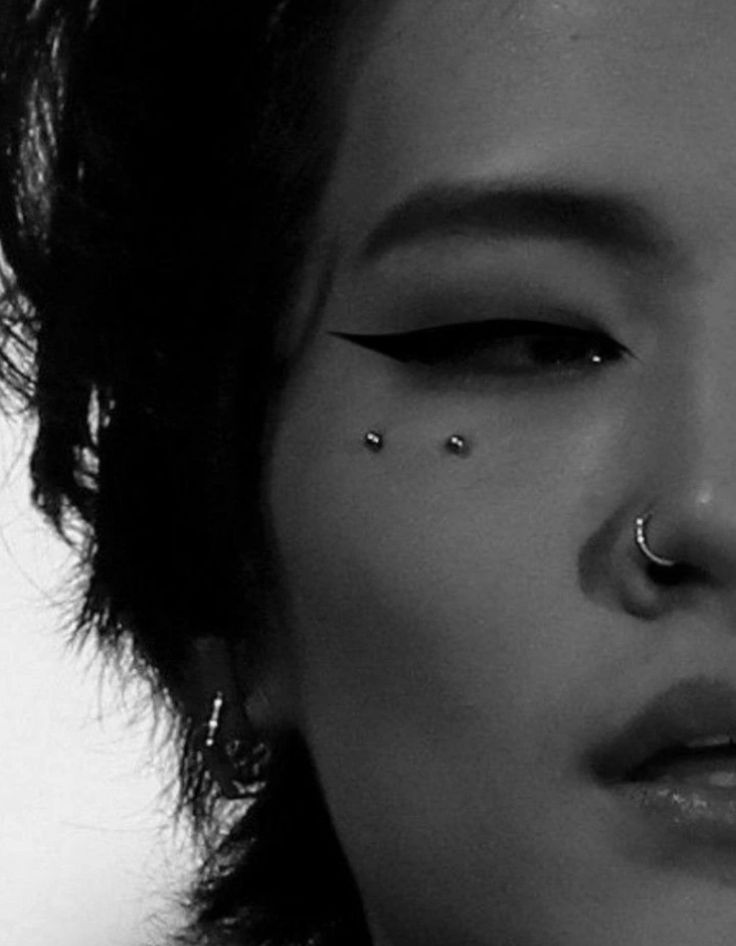 a woman with piercings on her nose looking at the camera