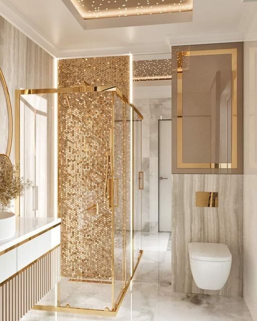 an elegant bathroom with gold accents and marble walls, along with a walk in shower