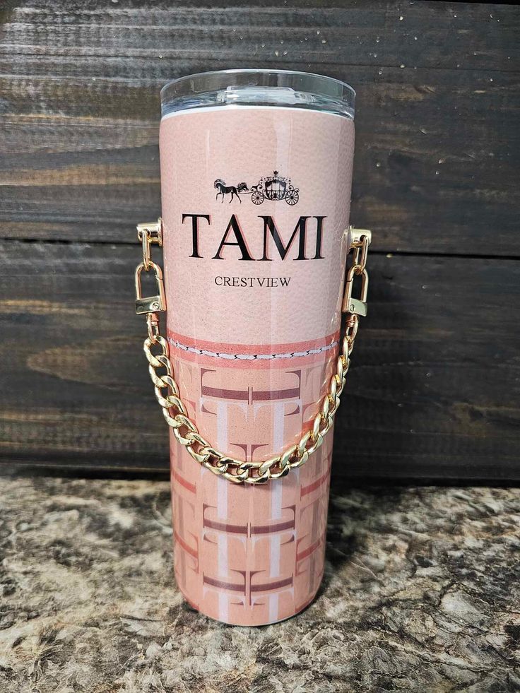 a pink tumbler with a chain on the handle and name tami crestview