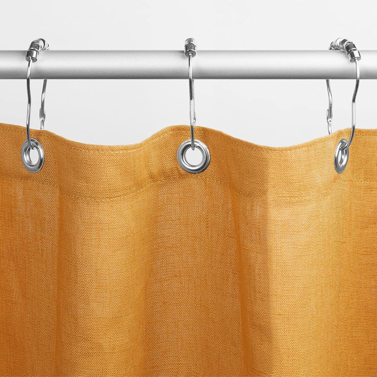 an orange curtain hanging from a metal rod