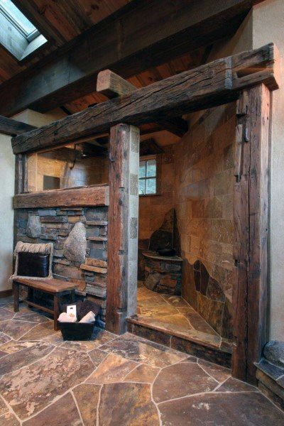 a stone fireplace in the corner of a room with wood beams and brick flooring