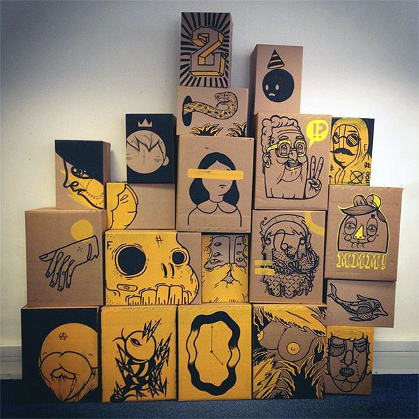 several cardboard boxes are stacked on top of each other and have different designs painted on them