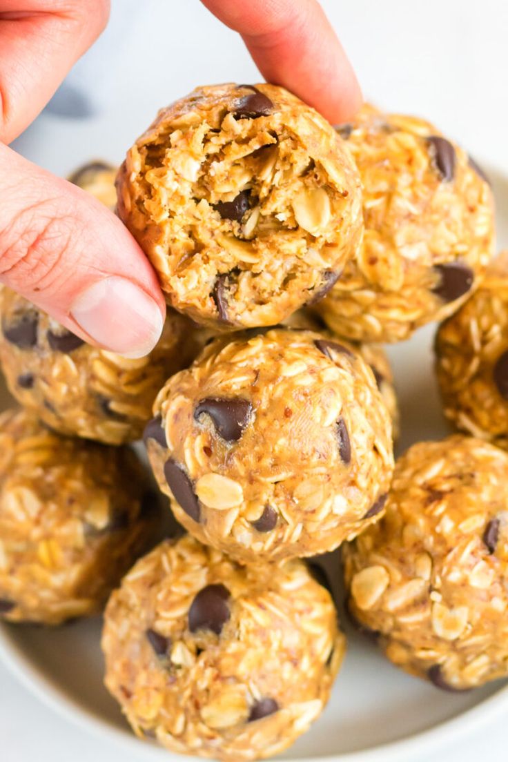 a person picking up some oatmeal balls from a plate