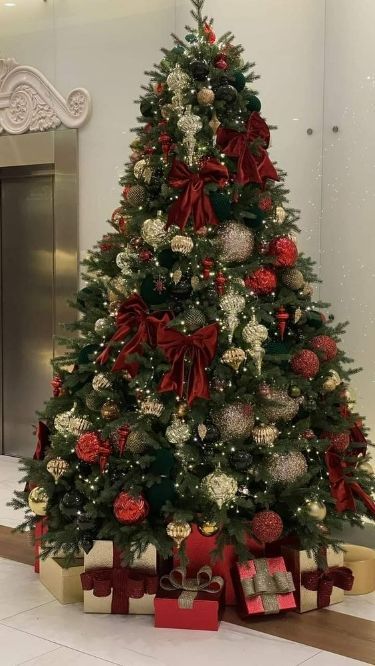 a christmas tree with presents under it in an office building, decorated for the holiday season