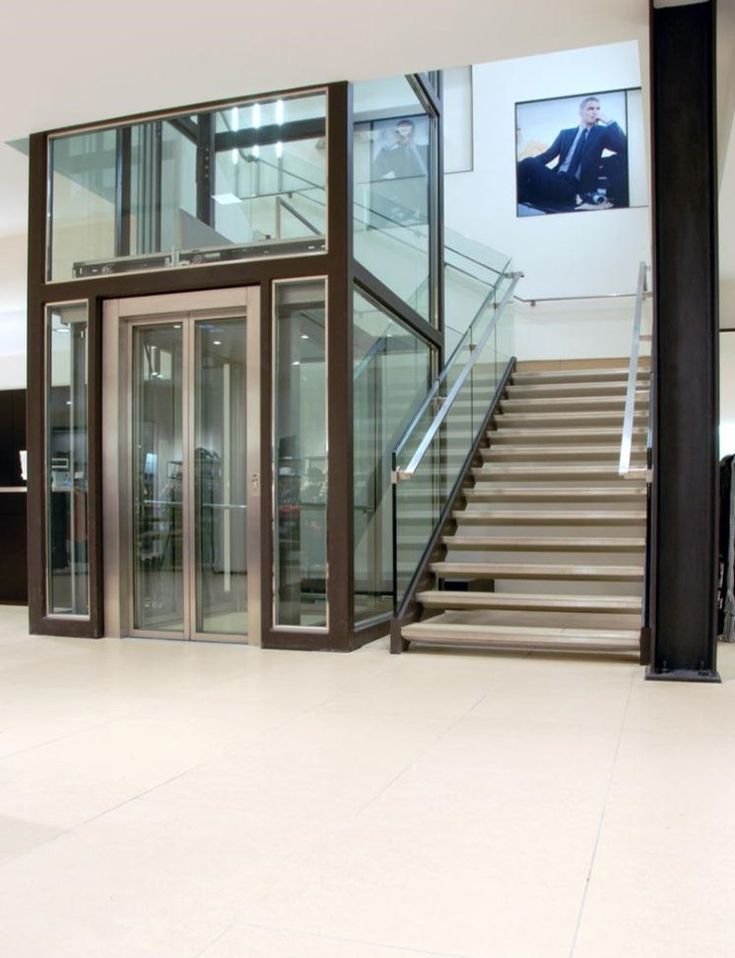 an empty lobby with stairs and glass doors