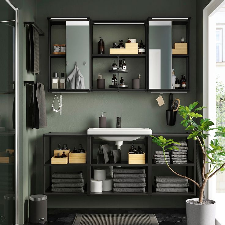 a bathroom with green walls and black tile flooring