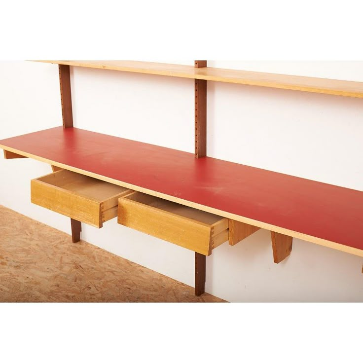 a red shelf with two drawers on it