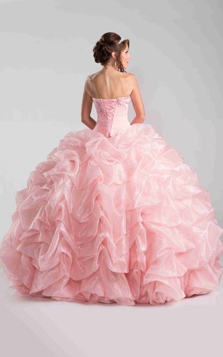 a woman in a pink ball gown with ruffles on the skirt and back