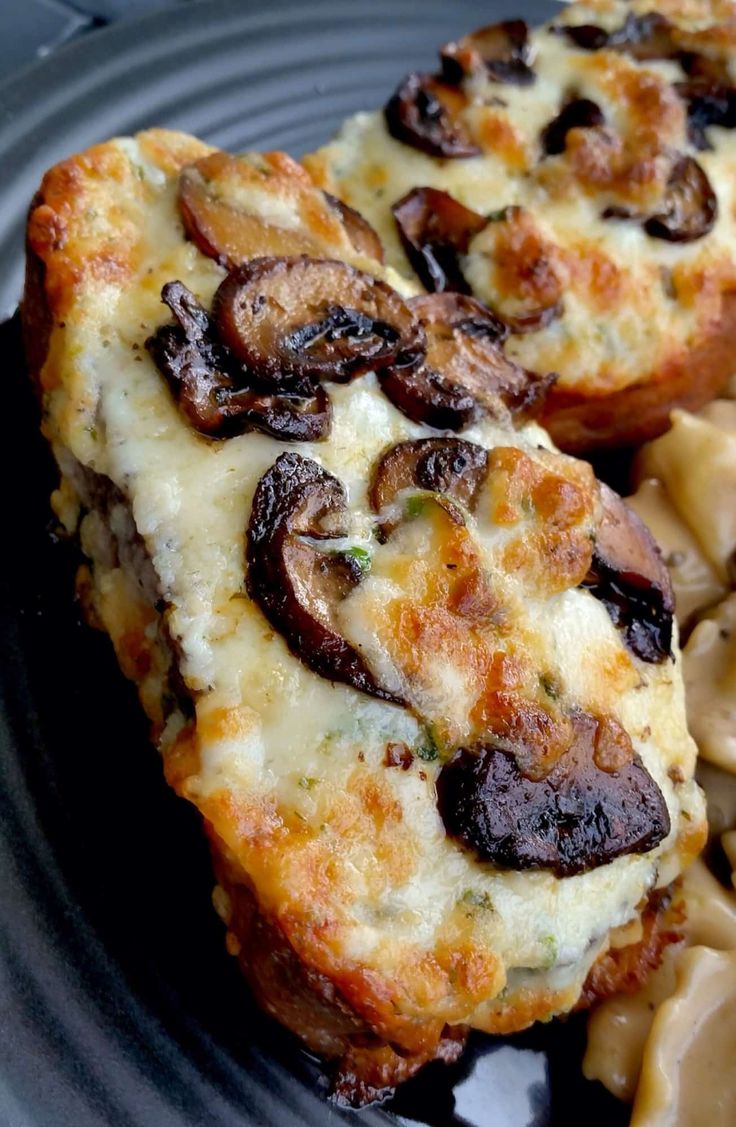 two pieces of pizza on a plate with pasta and mushrooms