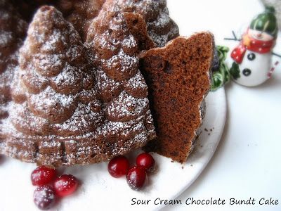 two pieces of chocolate bundt cake on a plate with cranberries and snowmen