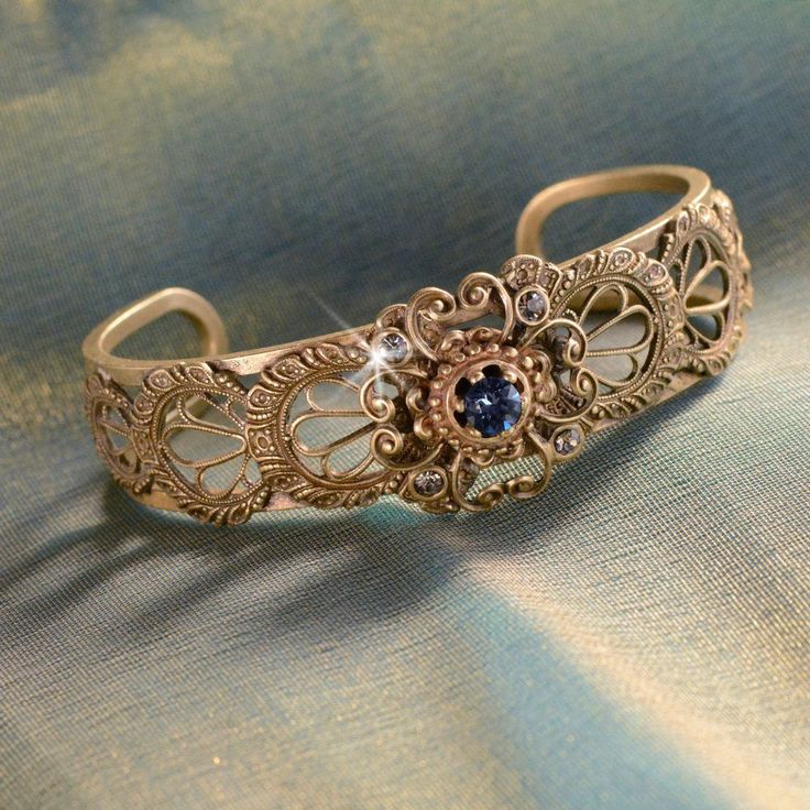 "Created from original vintage tools and dies, this bracelet has the appearance of the finest Spanish lace. A stunning bracelet for brides, bridesmaids, wedding party and Mother of the Bride. Fabricated by hand and torch, one delicate panel at a time is secured around the open cuff. Size: 7\" Made in our Los Angeles, CA studio. Contact us for bulk pricing and wholesale information." Antique Gold Engraved Bracelet, Art Nouveau Silver Jewelry For Ceremonial Occasions, Silver Art Nouveau Jewelry For Ceremonial Occasions, Ceremonial Vintage Jewelry With Historical Design, Elegant Bronze Bracelets For Collectors, Vintage Ceremonial Jewelry With Historical Design, Elegant Brass Bracelets For Ceremonial Occasions, Ornate Adjustable Bangle Bracelet, Heirloom Jewelry With Intricate Design For Collectors