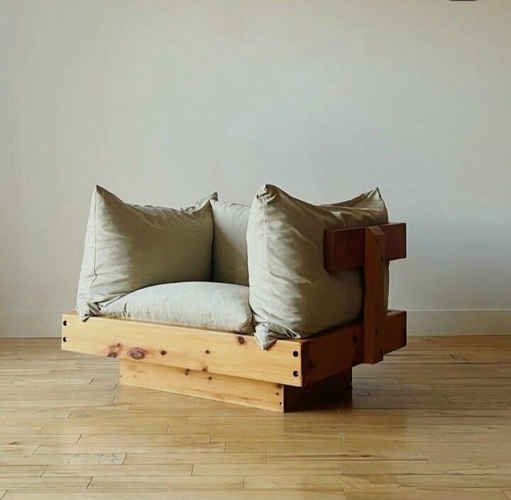 a couch made out of wooden pallets with two pillows on the back and sides