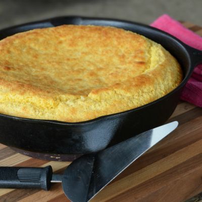 a skillet with some food in it on a cutting board next to a knife