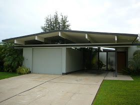 an empty garage with grass and trees in the background