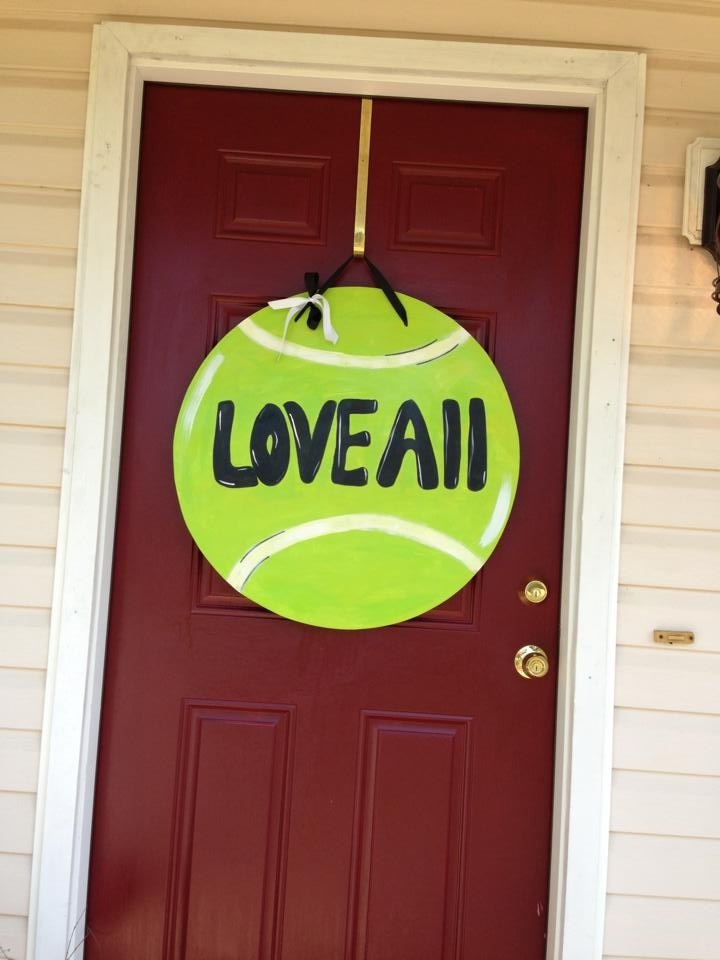 a tennis ball hanging on the front door of a house with loveall written on it