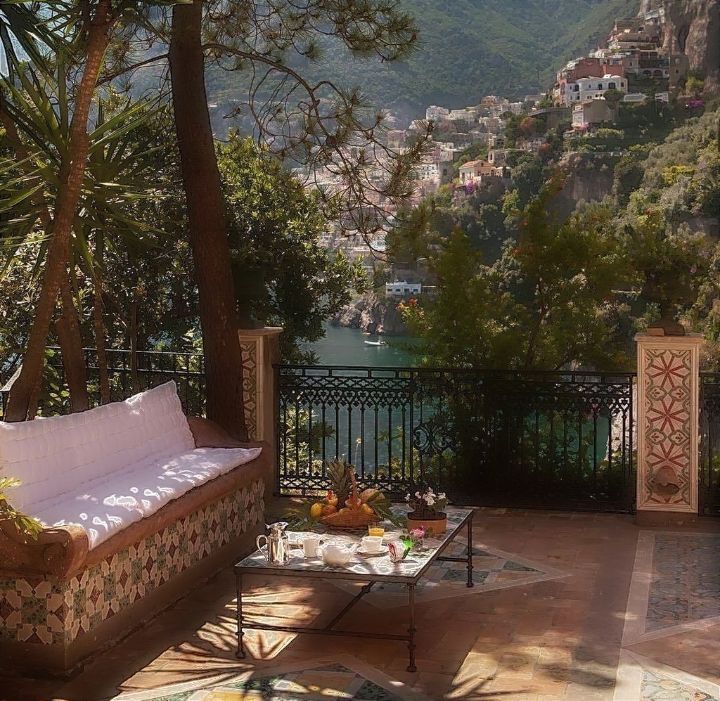 an outdoor seating area overlooking the water and mountains