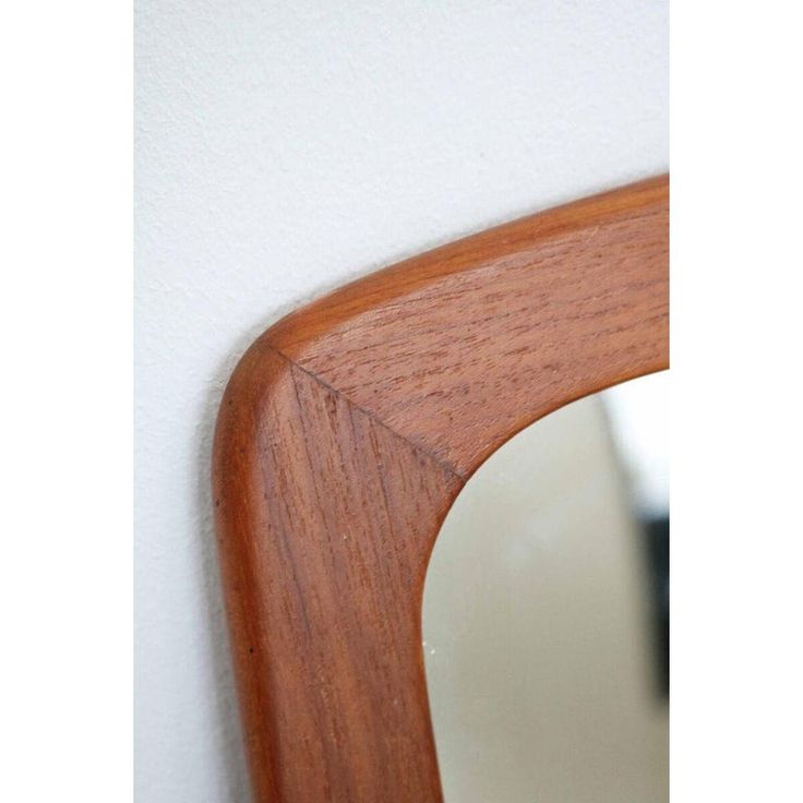 a close up of a mirror on a wall with a wooden frame and wood grain