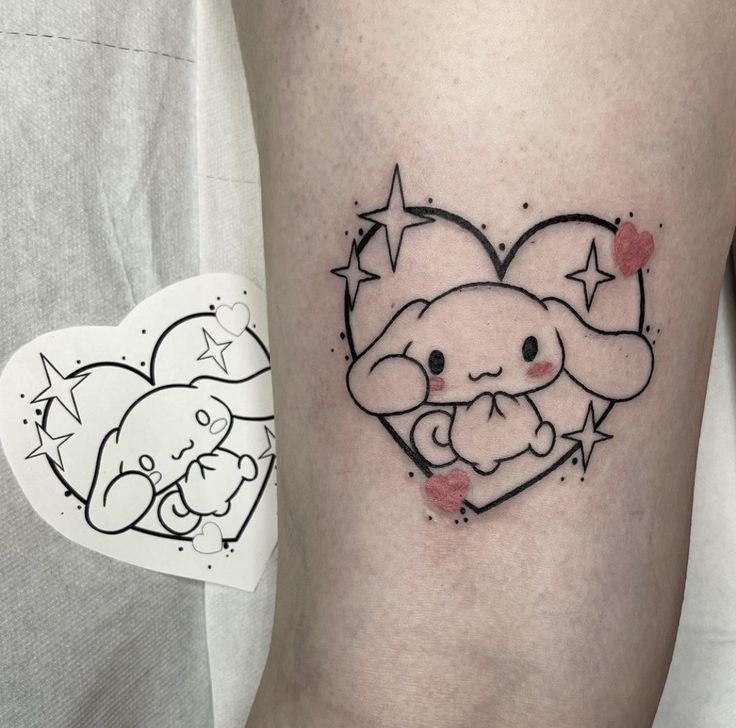 a small elephant tattoo on the thigh with hearts and stars around it's head