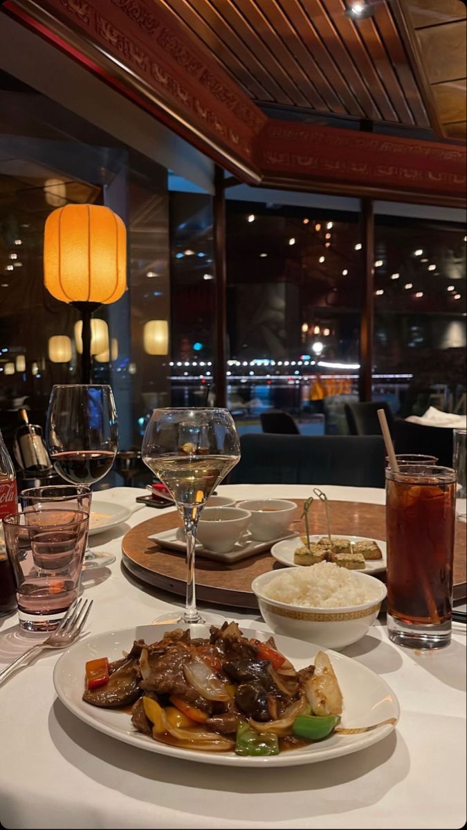 a table topped with plates of food and glasses of wine