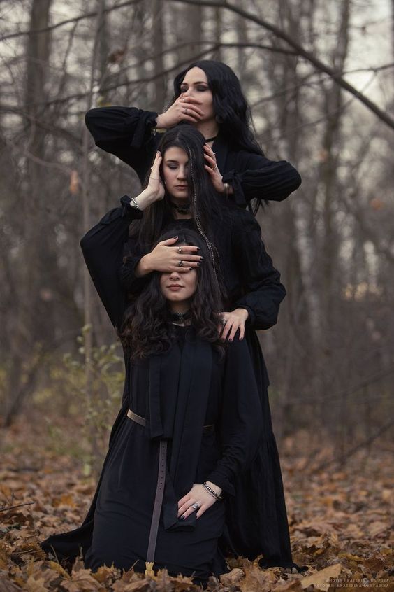 two women are standing in the woods with their heads on each other's shoulders