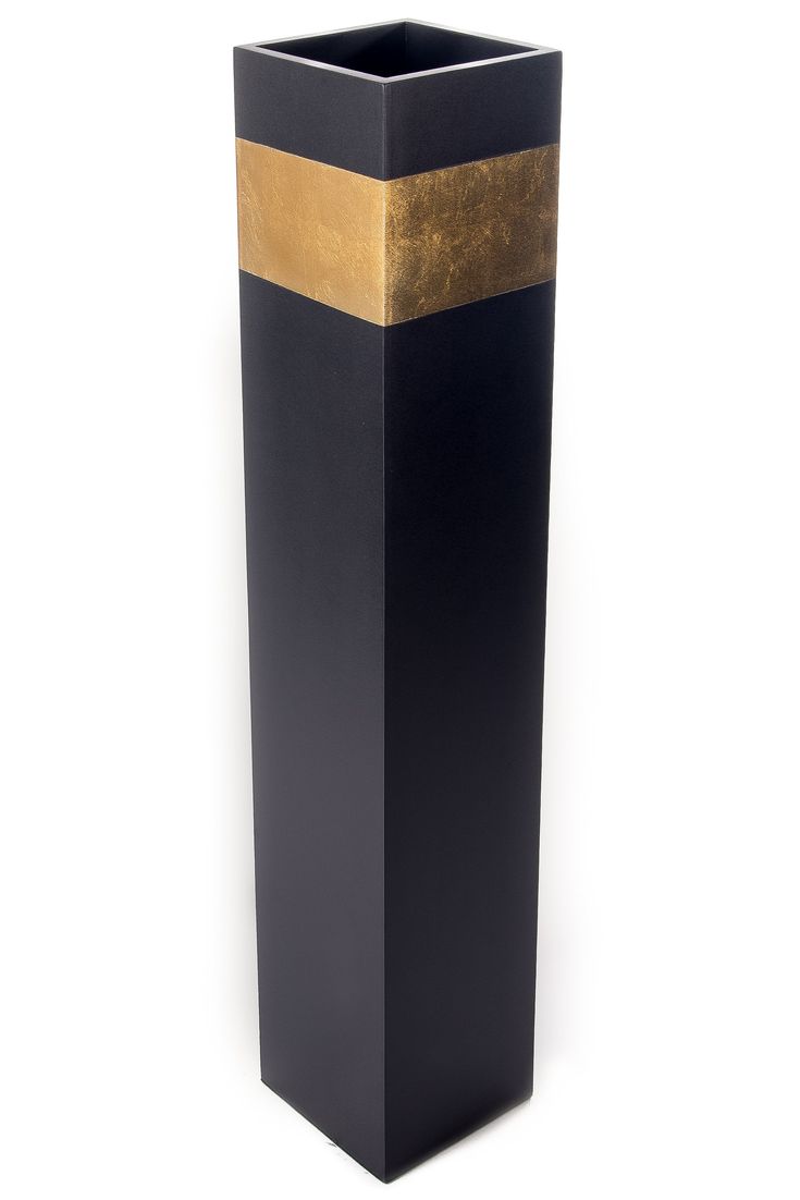 a tall black vase with gold stripes on the bottom and sides, sitting in front of a white background