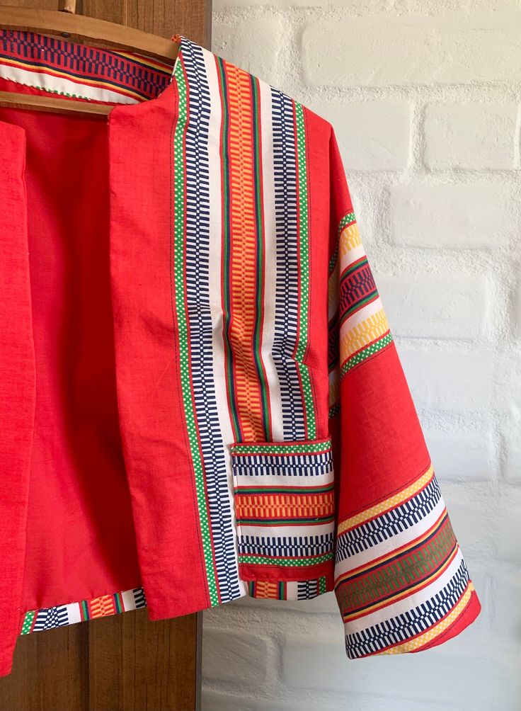 This colorful jacket is lightweight and perfect for a summer evening. Bright colors of red, yellow, and blue make up this vintage fabric. With 3/5 legnth sleeves, front pockets, and is lined in matching red. No closure, meant to be worn open. Would look great with high waisted jeans or a shirt. Summer Multicolor Outerwear With Kimono Sleeves, Multicolor Summer Outerwear With Kimono Sleeves, Multicolor Outerwear With Kimono Sleeves For Summer, Retro Red Outerwear For Spring, Red Outerwear With Kimono Sleeves For Spring, Festival Summer Outerwear With Pockets, Red Kimono Sleeve Outerwear For Spring, Red Summer Outerwear With Pockets, Red Summer Outerwear With Kimono Sleeves