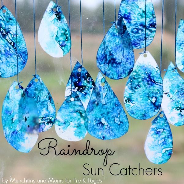 the sun catchers are hanging in front of a window with rain drops on them