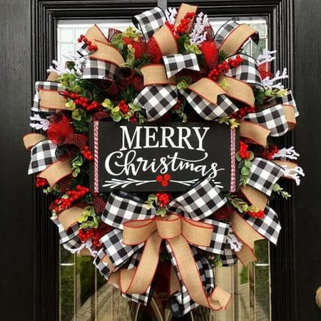 a merry christmas wreath hanging on the front door