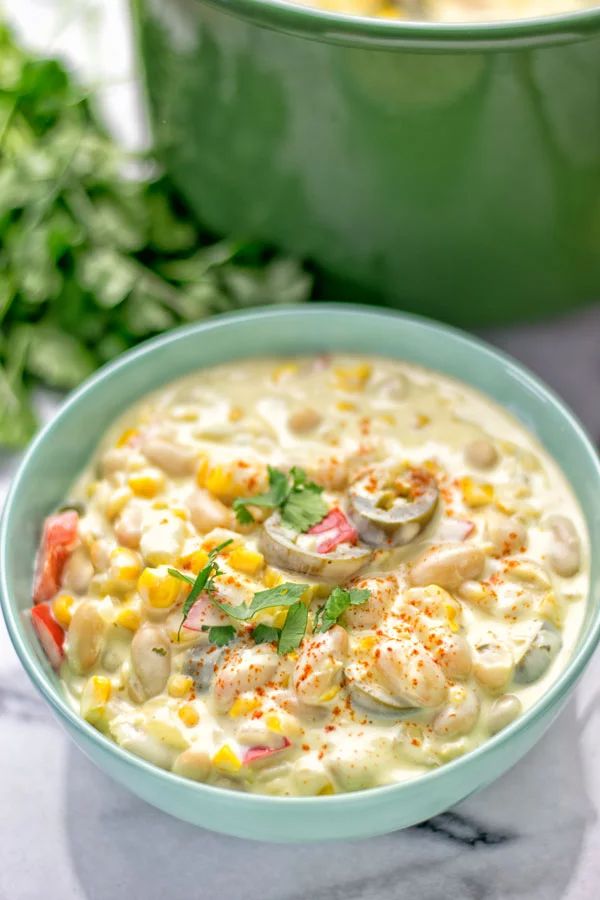 a bowl filled with soup next to a gold spoon