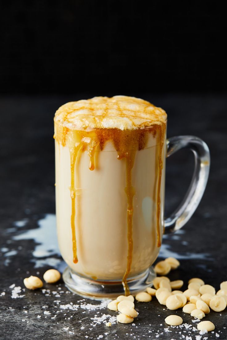 a glass mug filled with liquid and peanuts