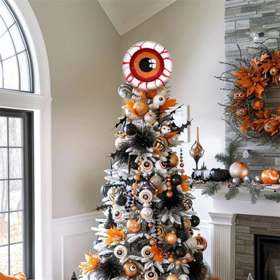 a decorated christmas tree with an evil eye decoration on it in front of a fireplace