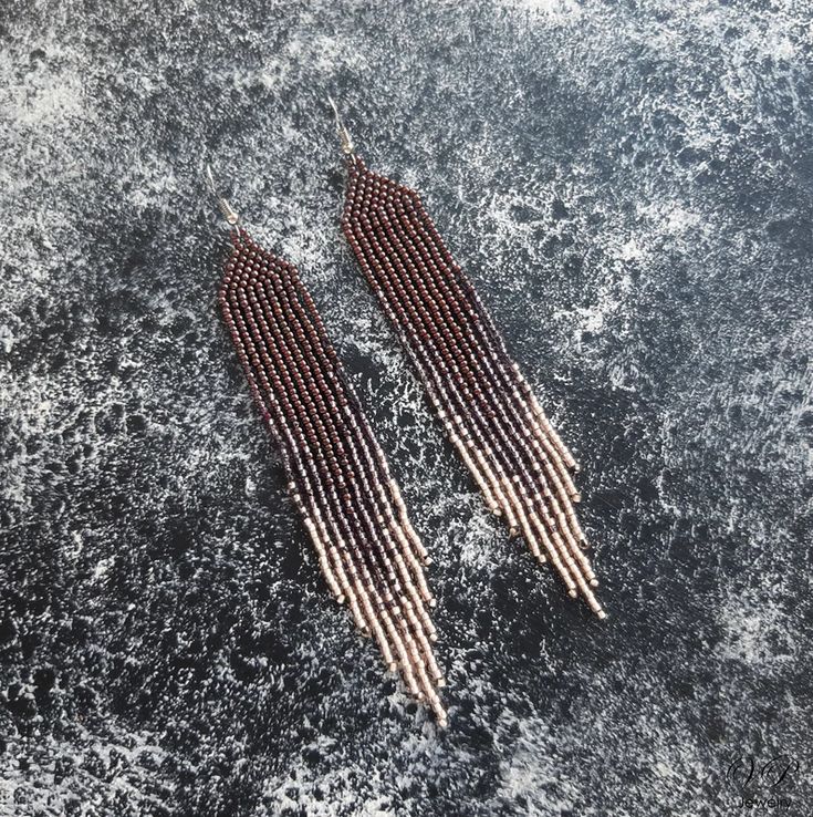 two pairs of red and white beaded earrings laying on top of the ocean water