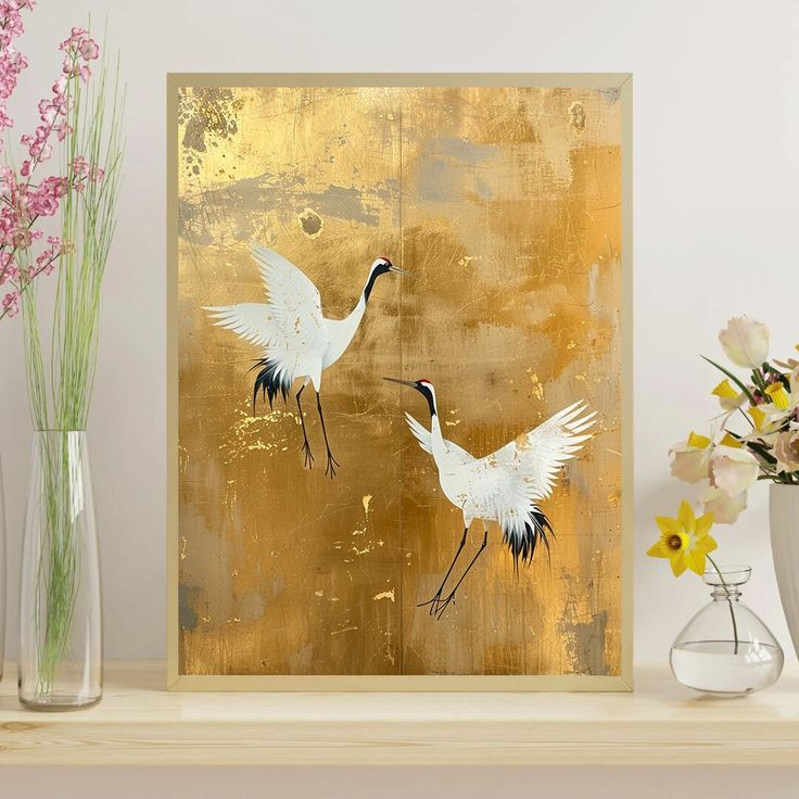 two white birds are standing next to each other on a shelf with vases and flowers