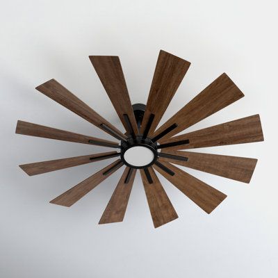 an overhead view of a ceiling fan with wood blades in the center and white wall behind it