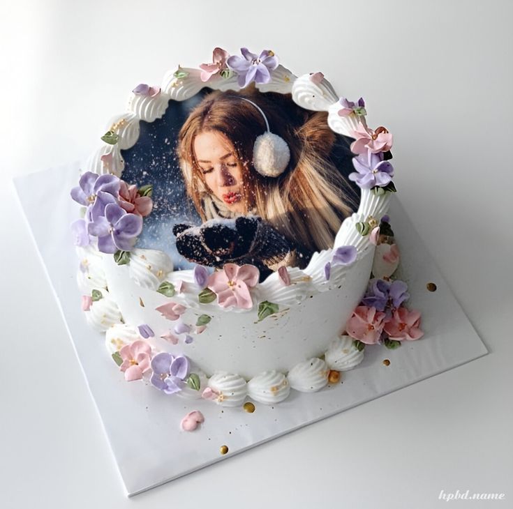 there is a cake decorated with flowers and a woman's face on the frosting