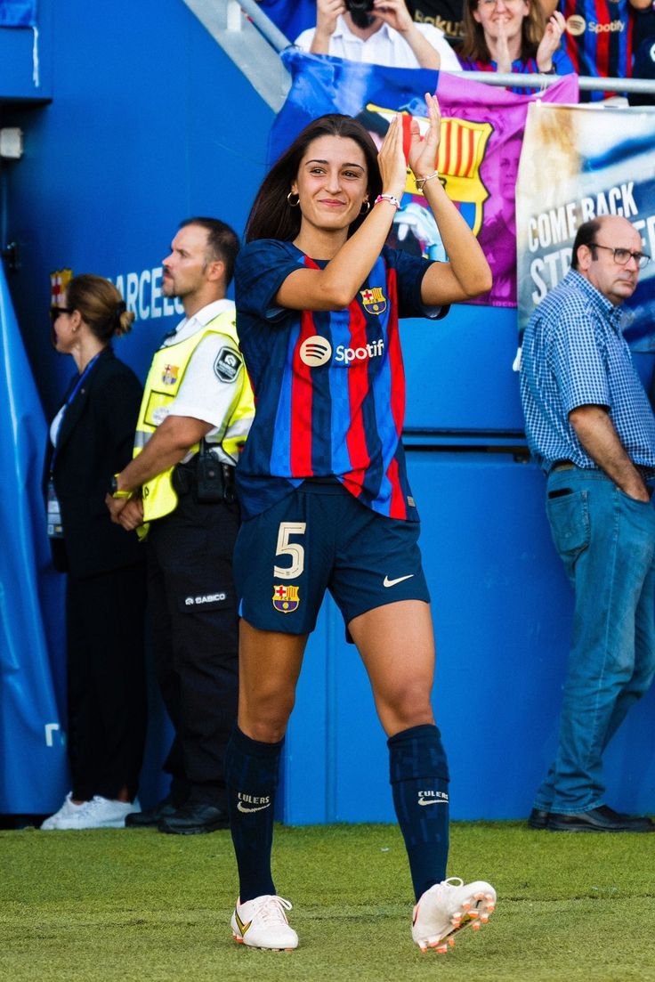 a female soccer player is standing on the field