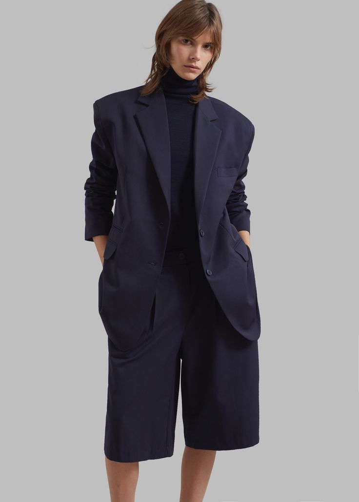 Color: Navy Midweight traditional suiting fabric Boxy fit Notch lapels Padded shoulders Illusion welt breast pocket Front flap pockets Button cuffs Side slits Front button closure Lined 65% Polyester 35% Rayon Dry Clean By The Frankie Shop. Imported Semi-formal Long Sleeve Pantsuit With Pockets, Formal Fall Pantsuit With Button Closure, Fall Formal Pantsuit With Button Closure, Chic Pantsuit With Suit Collar And Pockets, Notch Lapel Single Button Workwear Pantsuit, Semi-formal Button-up Suits With Pockets, Semi-formal Tailored Single-breasted Pantsuit, Structured Office Suits With Welt Pockets, Single Button Notch Lapel Pantsuit For Work