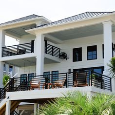 a white house with black balconies and balcony