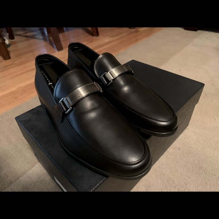 Made Of Iconic Saffiano Leather, These Loafers Are Characterized By The Logo On The Front Metal Tag. Upper: Saffiano Leather Logo Applied On The Enameled Metal Tag Upper With Apron Toe Rubber Sole Mens Prada 6. Made In Italy, Slip On, Smooth Calf Leather With The Bar On Top With Embedded Logo. This Is Unworn, New In The Box Designer Monk Strap Slip-on Shoes For Semi-formal Occasions, Modern Calf Leather Loafers For Semi-formal Occasions, Luxury Business Loafers With Removable Insole, Luxury Business Casual Dress Shoes, Designer Monk Strap Shoes With Leather Sole, Designer Business Loafers With Rubber Sole, Designer Goodyear Welted Leather Shoes For Business Casual, Luxury Loafers With Removable Insole For Semi-formal Occasions, Designer Goodyear Welted Loafers For Semi-formal Occasions