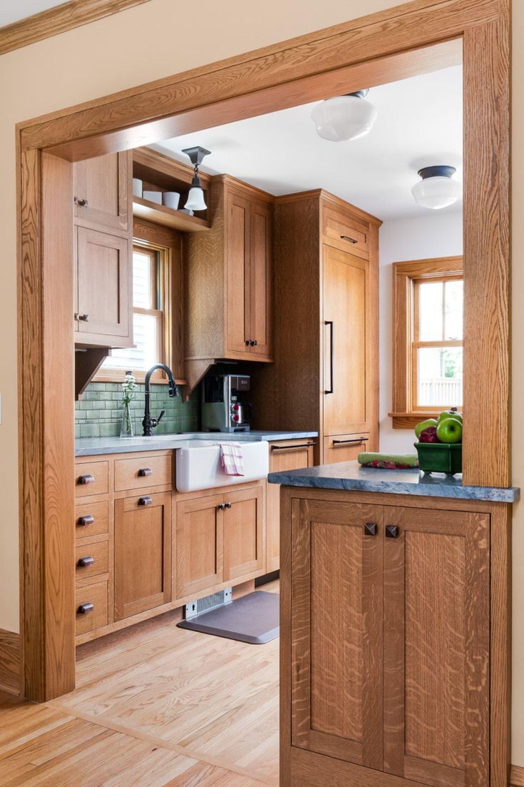 an open kitchen with wooden cabinets and black counter tops in the middle of the room