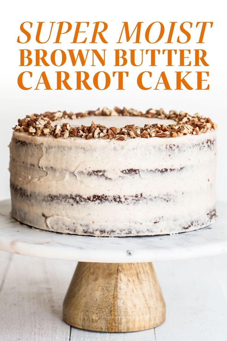 a cake with white frosting and walnuts on top sitting on a wooden stand