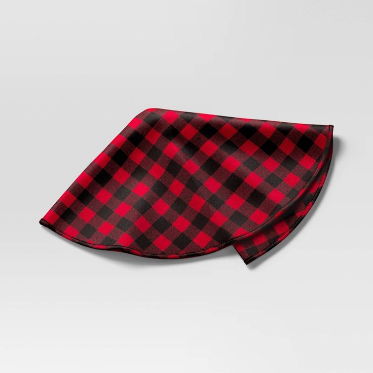 a red and black checkered tie laying on top of a white surface with no background