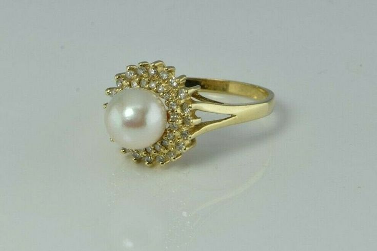 "14K Yellow Gold Pearl and Diamond Halo Ring, 7.5mm white pearl green and pink lustre, 2 rows of diamonds, halo .5\" across ring, Ring size 6.5, Circa 1970, 3.6 grams Stock # BB234R24 Most rings are sizable for a small fee. If the ring you are considering is the incorrect size contact us for a quote. This listing contains photographs of the actual item you will receive. Our items are in excellent condition with little or no signs of wear and many are one of a kind pre-owned estate finds. Please Round Diamond Pearl Ring, Formal Diamond Pearl Ring With Halo, Formal Diamond Halo Pearl Ring, Formal Pearl Ring With Diamond Halo Design, Formal Diamond Pearl Ring With Halo Setting, Formal Diamond Pearl Ring With Halo Design, Elegant Cluster Pearl Ring For Formal Occasions, Elegant Cluster Halo Ring, Formal Round Cut Halo Pearl Ring