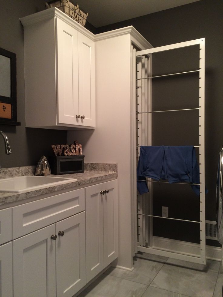 a bathroom with white cabinets and gray walls